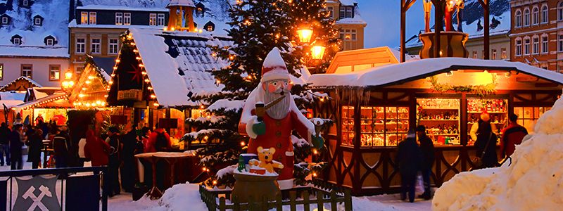 Marknadsbodar i ett vinterladskap bland jultomtar och belysning i Krakow.
